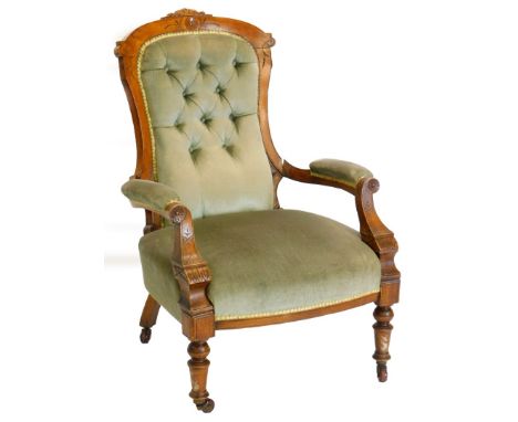 A Victorian walnut showframe open armchair, with a button padded back, padded arms and seat on turned tapering legs.