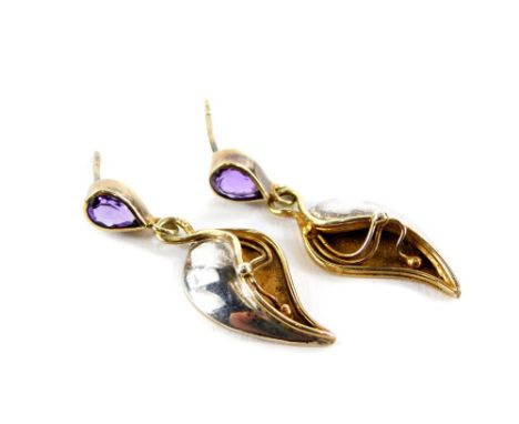 A pair of Art Nouveau style amethyst and silver drop earrings, the tear drop cut amethyst studs with a bi-colour lily drop, s