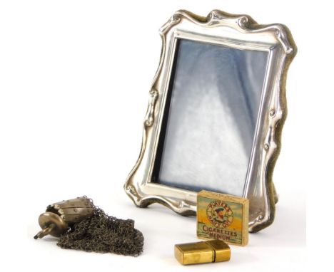 An Elizabeth II silver framed photograph frame, with scroll border, Sheffield 1990, 12cm high, a miniature brass cigarette li