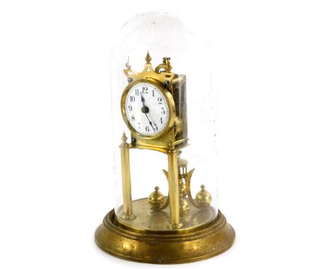 A Keininger and Obergfell brass Anniversary type clock, with a white enamel dial and a glass dome, 31cm high overall.