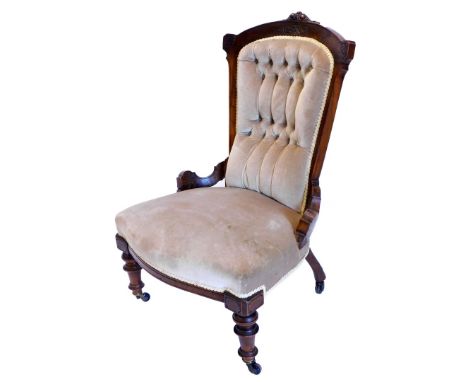 A late Victorian walnut nursing chair, with a padded button back, a padded seat on turned legs, with castors.