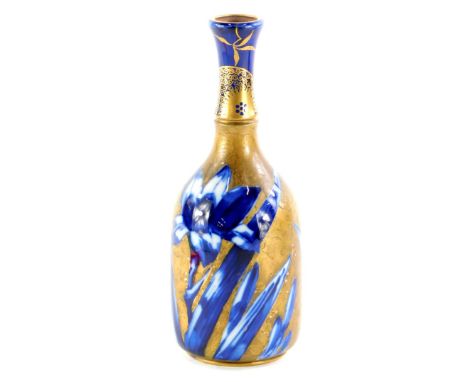 A Doulton ceramic bottle shaped vase, decorated with flowers in under glazed blue, with over decoration in gilt of further fl