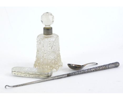 A George III plain old English pattern silver caddy spoon, a cut glass scent bottle with silver collar, a long button hook wi