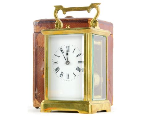 A brass carriage clock, with hour repeat, the white enamel dial with Roman numerals, the case with a swing handle, in leather