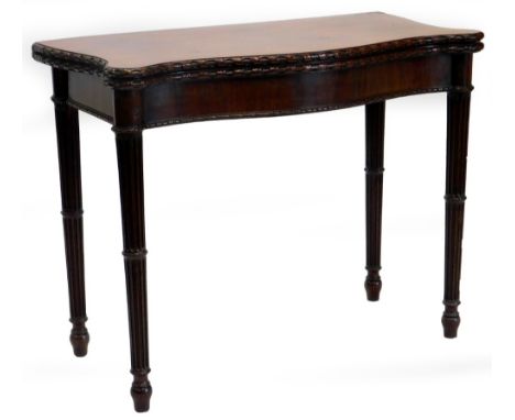 A George III mahogany card table, the serpentine shaped top with a carved border, enclosing a baize lined interior, above a p