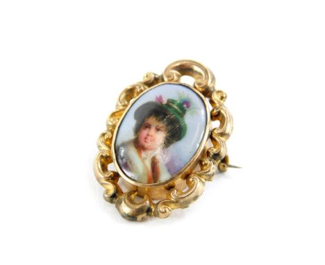 A late 19thC portrait memorial brooch, the oval portrait depicting a boy in feathered hat, in rococo scroll gilt metal border