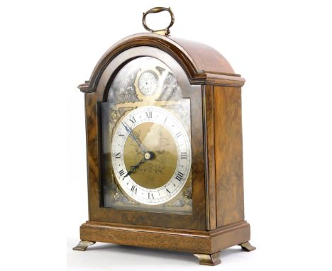 An Elliott mantel clock, in a walnut case, the arched dial stamped Tempus Fugit Made In England, 25cm high. 