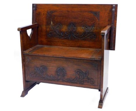 An early 20thC carved oak monk's bench, with a rectangular top with a moulded edge, on pierced end supports, the base with a 