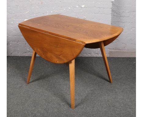 An Ercol light elm drop leaf dining table, on splay supports.  