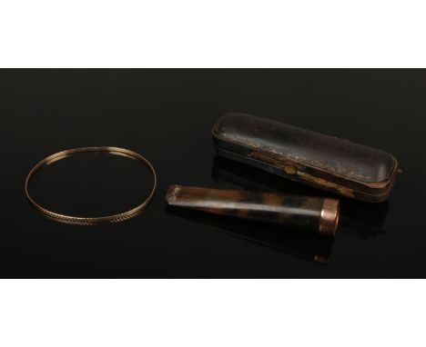 A 9ct gold bangle with etched decoration 2.8 grams, along with a cased cheroot holder with 9ct gold rim assayed London 1917. 