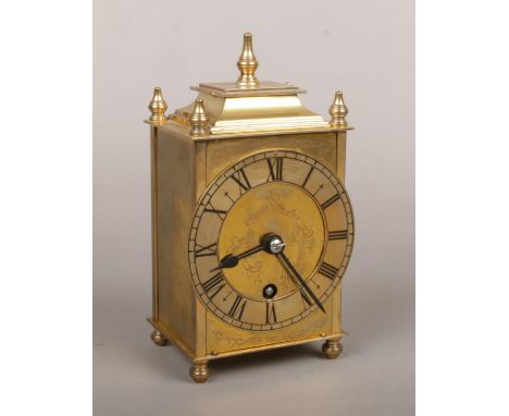 A Smiths Empire brass cased lantern form carrige clock. Having platform escapement, with turned finials and raised on toupie 