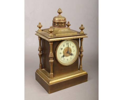 A brass mantle clock with column supports, chiming on a coiled gong.  Crack to dial. Door slightly bent.