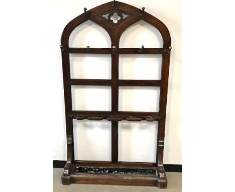 A Victorian oak hall stand, Gothic style pierced form with brass coat hooks above umbrella and stick stand and pan, 110cm wid