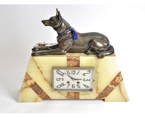 A large Art Deco marble and onyx mantel clock, surmounted with a spelter Alsatian, 38cm high x 45cm wide x 10cm deep 