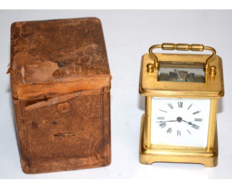 A brass carriage timepiece, the enamel dial with Roman numerals, with glass surround and original case, height 10cm 