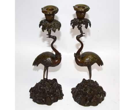 After Thomas Abbott, a pair of bronze figural candlestick holders, taking the form of cranes supporting bowls, with crowns ar