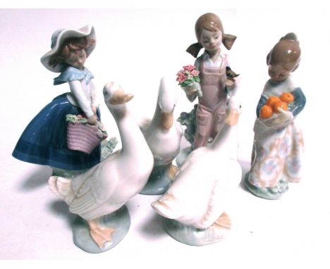 Three Lladro figures of girls,  5217 girl with songbird, 4841 girl with oranges and a girl with a flower filled basket, toget