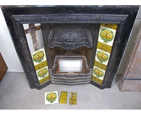 An Art Nouveau cast iron combination fireplace, blacked cast iron surround with original floral decorated ceramic tiles to ei