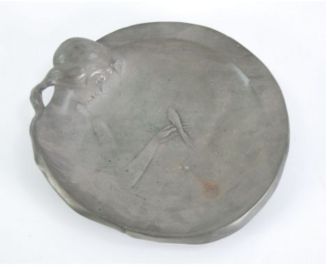 ART NOUVEAU EMBOSSED PEWTER SHALLOW CIRCULAR DISH, design of a girl holding a tail bird, her flowing hair forming a loop hand