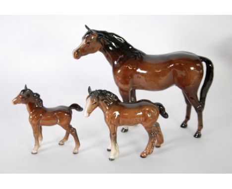BESWICK BROWN GLAZED POTTERY MODEL OF A MARE, facing left, 7 1/2" (19cm) high, TOGETHER WITH THREE BESWICK BROWN GLAZED MODEL