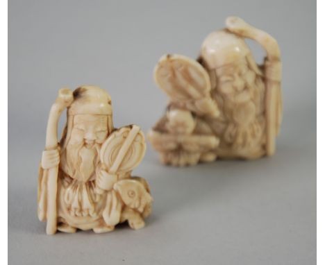 JAPANESE EARLY 20th CENTURY CARVED BONE NETSUKE in the form of a seated deity holding a staff and fan next to a reclining sta