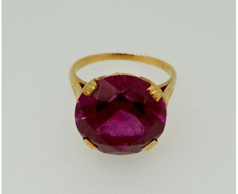 A gold ring set large purple stone - mark worn, 1.5cm diameter, size M 