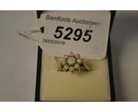 A nine stone opal floral cluster ring, central larger round cabochon opal, surrounded by a band of eight smaller conforming s