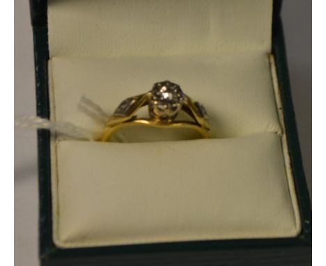 An 18ct gold and platinum solitaire diamond illusion set ring, diamond chips to shoulders, 3g