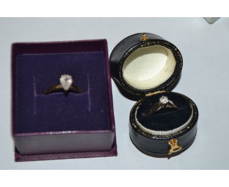 A gold and diamond solitaire ring; another