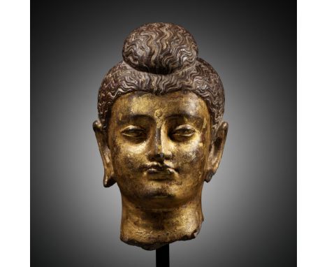 A PARCEL-GILT SCHIST HEAD OF BUDDHA SHAKYAMUNI, KUSHAN PERIODExpert's note: While it is reasonable to assume that many schist