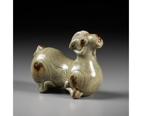 A RARE IRON-SPLASHED 'YUE' FIGURE OF A RECUMBENT RAM, WESTERN JIN DYNASTYChina, 3rd century. The well-modelled ram with its f