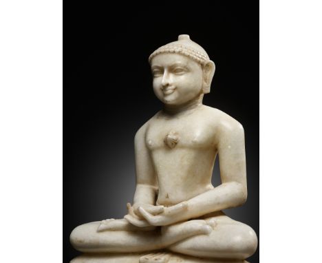 A JAIN WHITE MARBLE FIGURE OF A TIRTHANKARA, WESTERN INDIA, 17TH-18TH CENTURYSeated in padmasana on a cushioned throne, the f