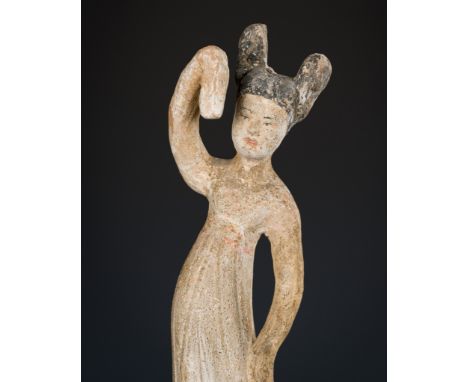 A PAINTED POTTERY FIGURE OF A DANCING LADY, TANG DYNASTYChina, 618-907. Well modeled, depicted in an animated pose with the b