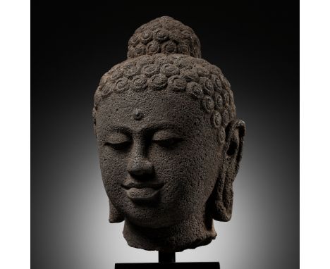 AN IMPORTANT OVER-LIFESIZE ANDESITE HEAD OF BUDDHA, CENTRAL JAVANESE PERIOD, INDONESIA, 9TH CENTURYExpert's note: The current