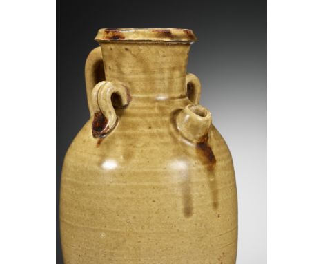 AN IRON-SPLASHED AND AMBER-GLAZED EWER, TANG DYNASTYChina, 618-906. The ovoid body rises from a broad foot to a flaring neck,