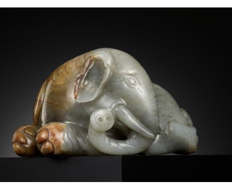 A GRAY AND RUSSET JADE FIGURE OF A RECUMBENT ELEPHANT, LATE MING TO MID-QING DYNASTYChina, 17th-18th century. Carved from a l