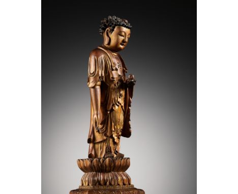 A LACQUER-GILT WOOD FIGURE OF THE STANDING BUDDHA, CHINA, 17TH - 18TH CENTURYThe figure with a downcast gaze, standing tall, 