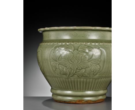 A LARGE CARVED LONGQUAN CELADON JARDINIERE, EARLY MING DYNASTYChina, 14th century. Heavily potted, the rounded sides stand ab