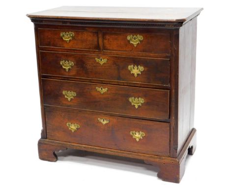 A George III oak chest of drawers, the rectangular top, moulded edge and canted corners above a Greek key carved frieze, with