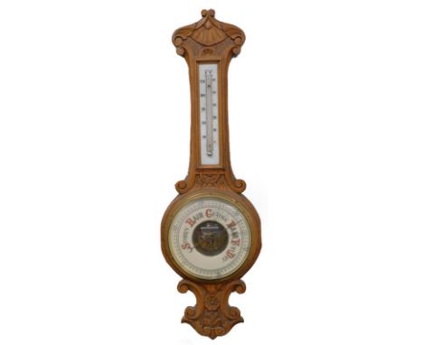 A late 19th/early 20thC carved oak aneroid barometer, in a banjo shaped case, 81cm long overall.