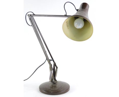 A brown Anglepoise lamp, on a circular foot.