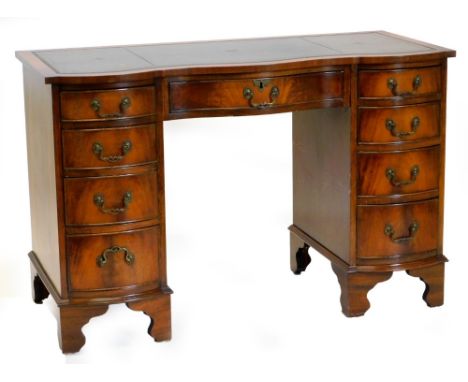 A mahogany kneehole desk, the top with a serpentine front and a green leather insert above nine drawers on bracket feet, 76cm