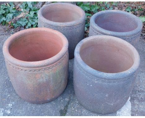 A set of four ceramic garden pots, each with a shaped edge, shades varying, 40cm high, 42cm diameter.