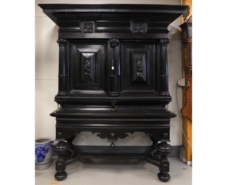 An ebony two-door cabinet, Holland, 2nd half of the 17th century. Profiled straight roof with two carved medallions, panelled