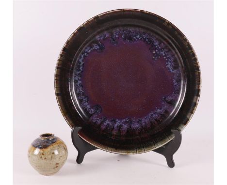 Boerrigter, Han (Nijmegen 1935 ) A purple glazed ceramic dish, signed verso and 1982, Ø 31 cm. Comes with a spherical vase, t
