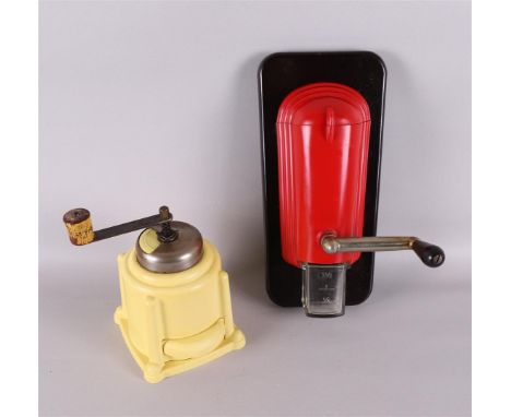A red Bakelite wall coffee grinder, ca. 1930. This includes a yellow Bakelite hand coffee grinder, tot. 2x.