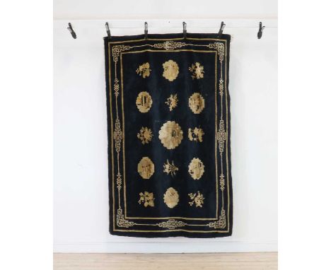A Chinese Beijing rug,early 20th century, with panels of previous objects to a navy field,203 x 134cmCondition ReportHeavily 