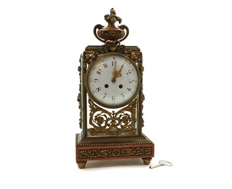 A French brass and rouge marble mantel clock 19th century, the circular white enamel dial within a bevelled glass case, embel