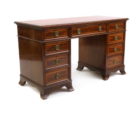 An Edwardian strung mahogany kneehole desk,with a tooled red leather inset over nine drawers and bracket feet,137cm wide61cm 