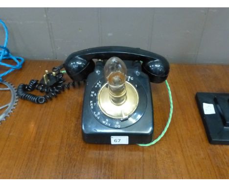A black bakelite telephone converted to form a table lamp

 CONDITION REPORT: Working order unknown